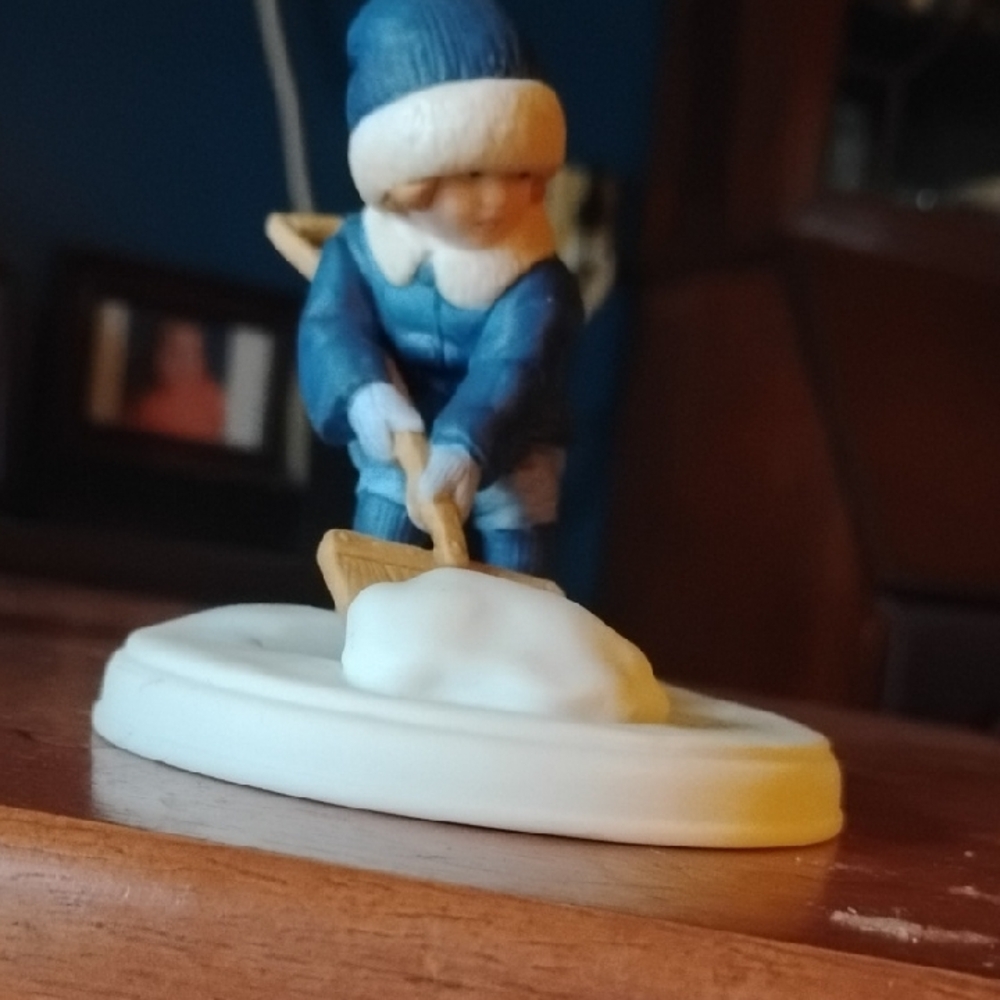Blue and White Figurine of Child Shoveling Snow